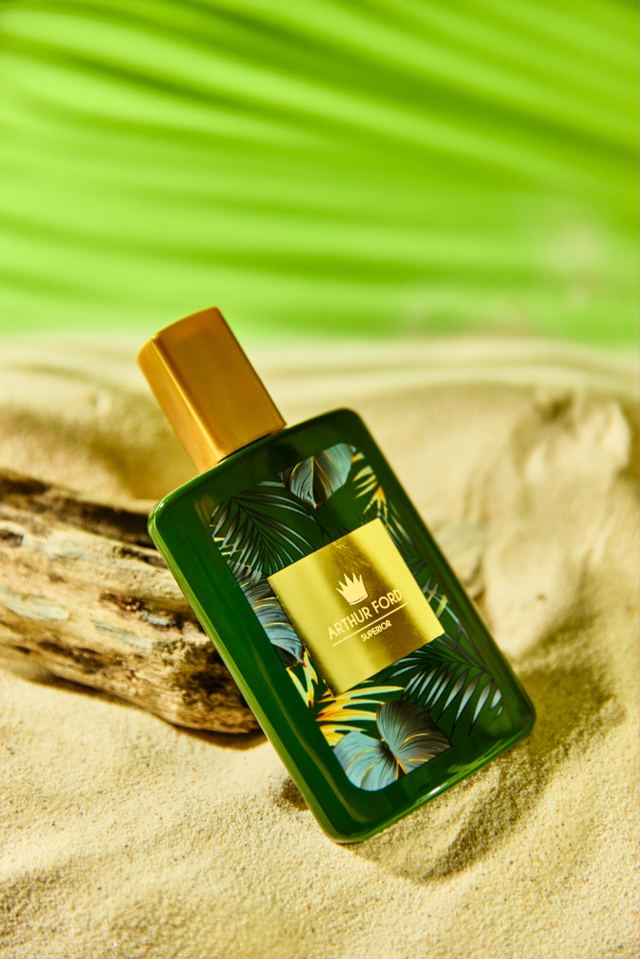 Green tropical bottle on sand and driftwood