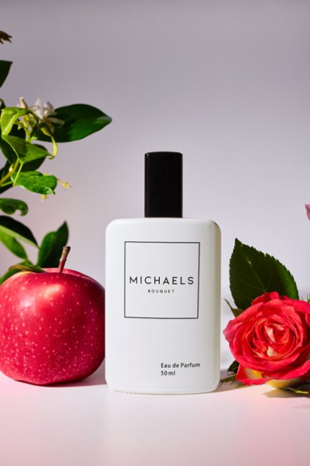 White Michaels Bouquet bottle between a red apple and a coral rose