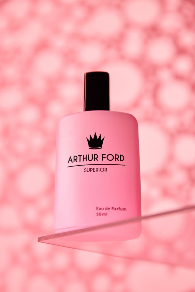 Pink bottle on glass against a pink bubble background