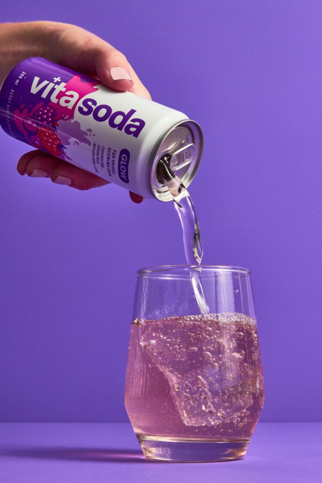 Vita Soda being poured into a glass on purple